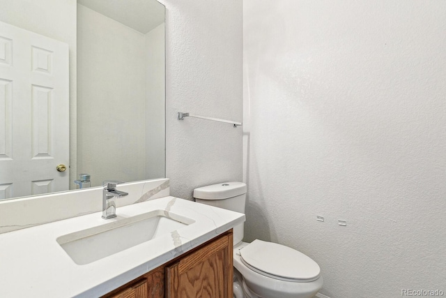 15762 Olmsted Pl, Denver, CO 80239 - half bathroom with a textured wall, vanity, and toilet