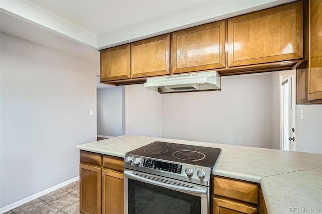 kitchen with light tile patterned floors and stainless steel range with electric stovetop