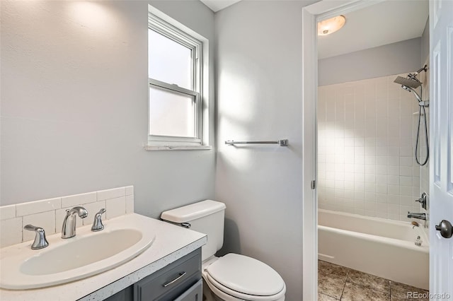 full bathroom with tile patterned flooring, tiled shower / bath, vanity, and toilet