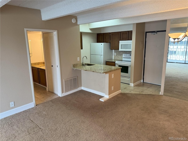 777 N Washington St Unit 1007, Denver, CO 80203 - kitchen featuring white appliances, light colored carpet, a peninsula, and light tile patterned floors
