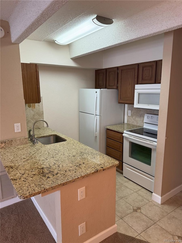 777 N Washington St Unit 1007, Denver, CO 80203 - kitchen with white appliances, a peninsula, tasteful backsplash, light stone counters, and a textured ceiling