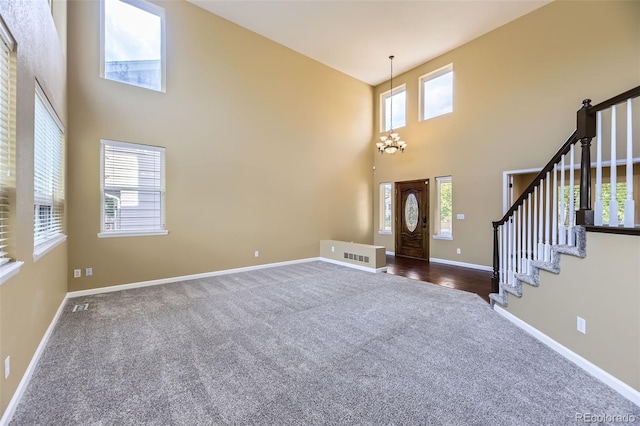 9975 Blackbird Cir, Highlands Ranch, CO 80130 - entrance foyer featuring dark carpet, a towering ceiling, and stairs