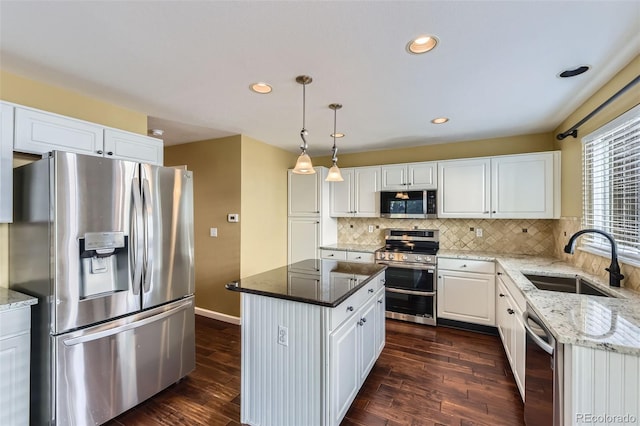 9975 Blackbird Cir, Highlands Ranch, CO 80130 - kitchen featuring stainless steel appliances, dark wood-style flooring, light stone counters, white cabinetry, and recessed lighting