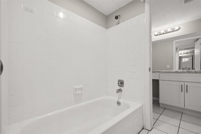 bathroom featuring vanity, tile patterned flooring, and tiled shower / bath