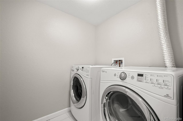 laundry room with washing machine and dryer and light tile patterned flooring