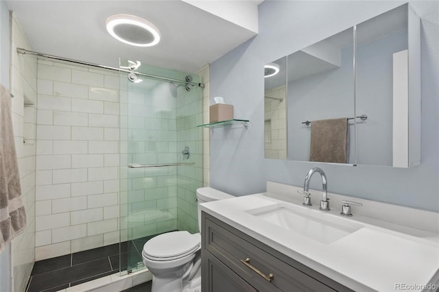 bathroom featuring vanity, a shower with shower door, and toilet