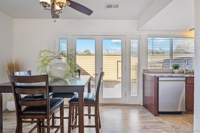 dining room with light wood-style flooring, visible vents, and a wealth of natural light