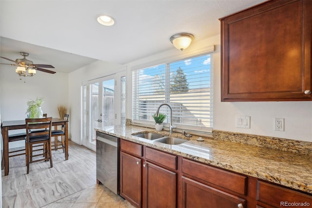 kitchen featuring light stone counters, a sink, stainless steel dishwasher, and ceiling fan