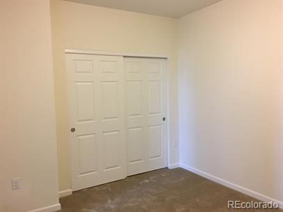 804 Summer Hawk Dr Unit 6105, Longmont, CO 80504 - unfurnished bedroom featuring a closet and dark colored carpet