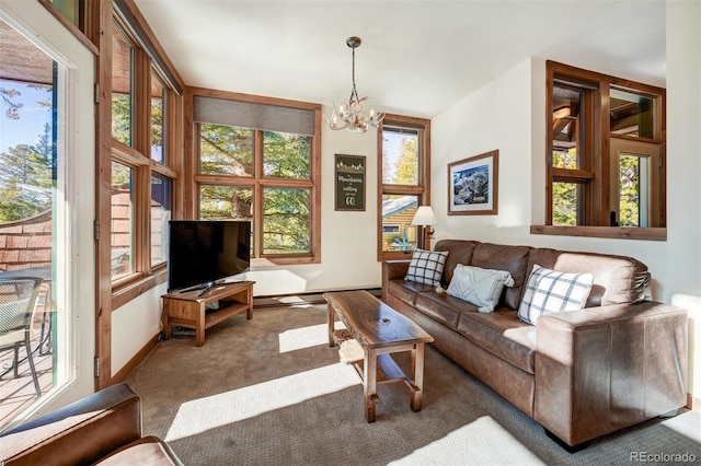 living room with a notable chandelier, dark carpet, and a baseboard heating unit