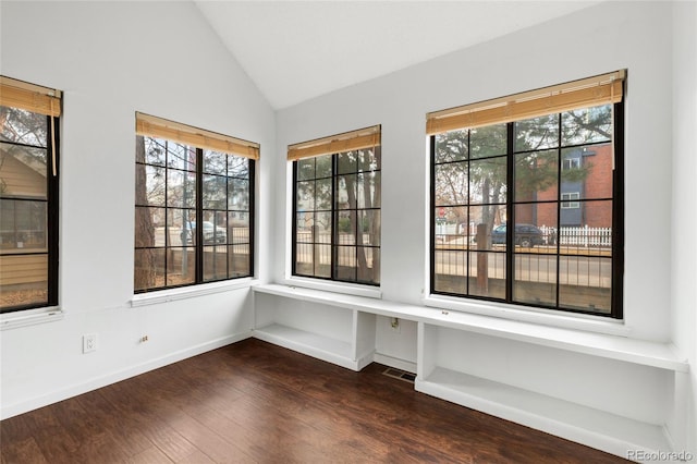 interior space with lofted ceiling, dark wood-style flooring, visible vents, and baseboards