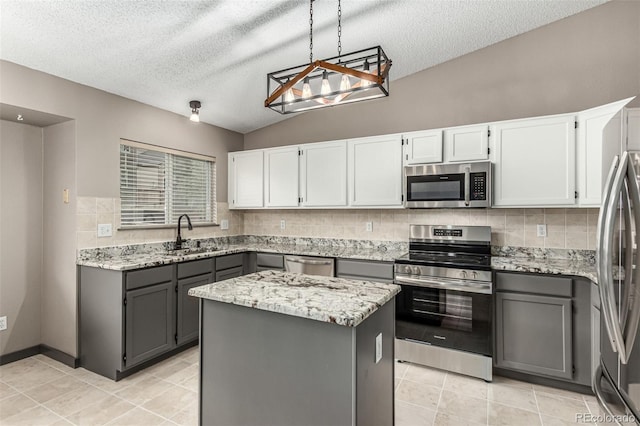 10172 Woodrose Ln, Highlands Ranch, CO 80129 - kitchen with stainless steel appliances, gray cabinetry, light stone countertops, backsplash, and a center island