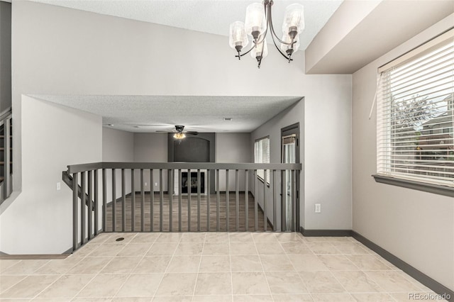 10172 Woodrose Ln, Highlands Ranch, CO 80129 - hallway featuring a textured ceiling, a chandelier, light tile patterned floors, and an upstairs landing
