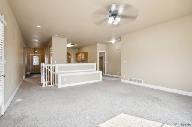 unfurnished living room featuring carpet and ceiling fan