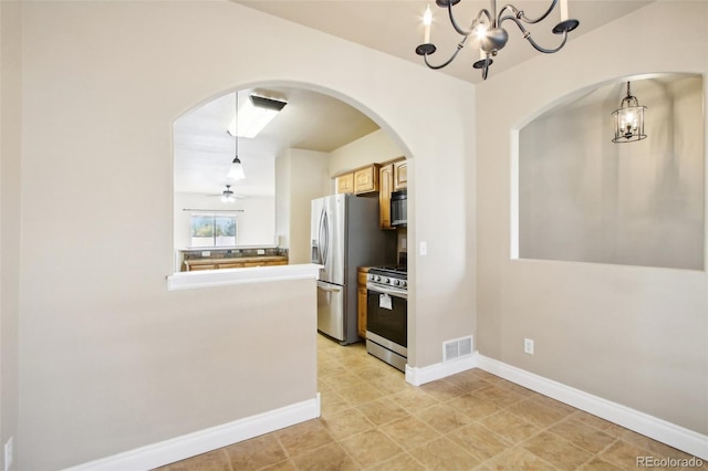 kitchen featuring ceiling fan with notable chandelier, stainless steel appliances, hanging light fixtures, and light tile patterned floors