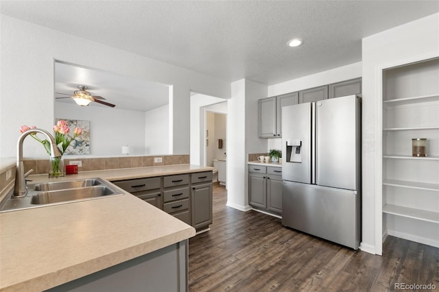 kitchen featuring sink, dark hardwood / wood-style floors, stainless steel fridge, gray cabinets, and kitchen peninsula