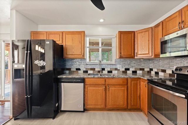 4627 S Norfolk Way, Aurora, CO 80015 - kitchen featuring stainless steel appliances, brown cabinetry, decorative backsplash, and recessed lighting