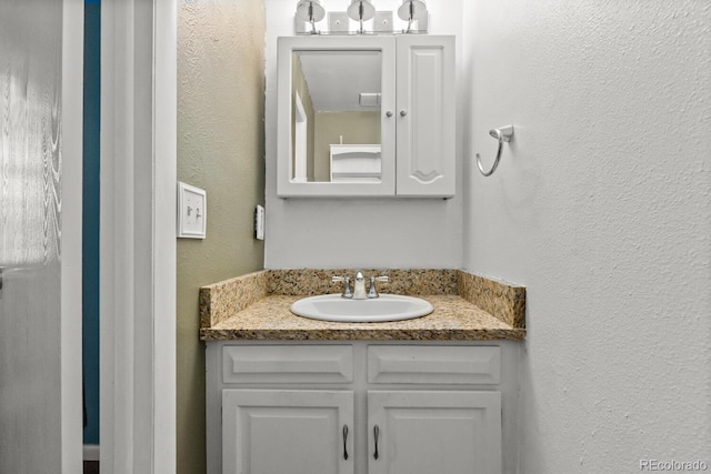 4627 S Norfolk Way, Aurora, CO 80015 - bathroom featuring a textured wall and vanity