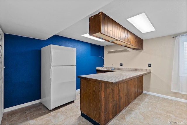 4627 S Norfolk Way, Aurora, CO 80015 - kitchen with freestanding refrigerator, a peninsula, and light countertops