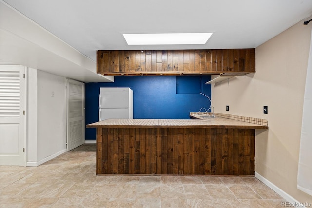 4627 S Norfolk Way, Aurora, CO 80015 - kitchen featuring freestanding refrigerator, a peninsula, and light countertops