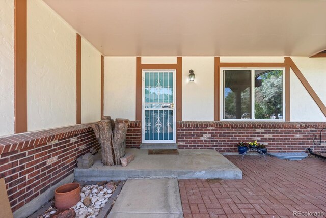 4627 S Norfolk Way, Aurora, CO 80015 - doorway to property featuring stucco siding and brick siding