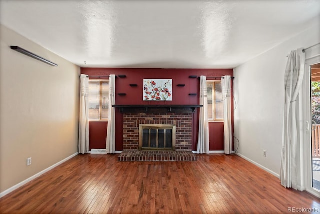 4627 S Norfolk Way, Aurora, CO 80015 - unfurnished living room featuring wood-type flooring and a brick fireplace