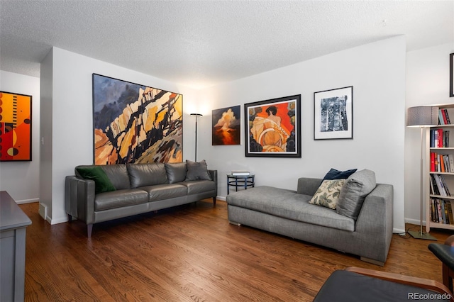 living area with a textured ceiling, wood finished floors, and baseboards