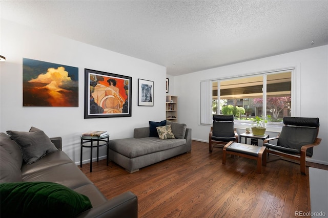 living area featuring a textured ceiling, baseboards, and wood finished floors