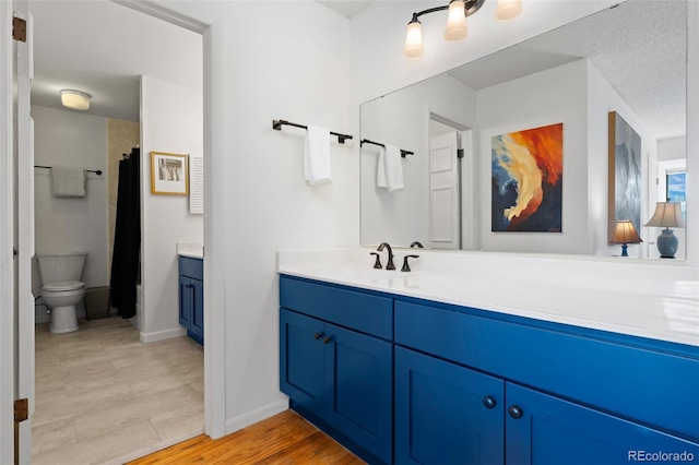 bathroom featuring vanity, toilet, and baseboards