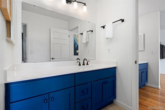 bathroom featuring baseboards, vanity, and wood finished floors