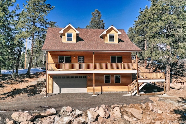 view of front of property with driveway, log veneer siding, stairway, roof with shingles, and an attached garage