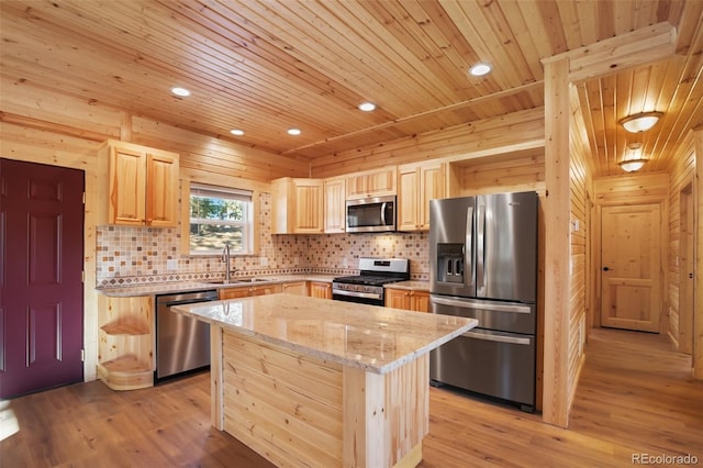 kitchen with light brown cabinets, light stone countertops, appliances with stainless steel finishes, light wood-style floors, and a sink