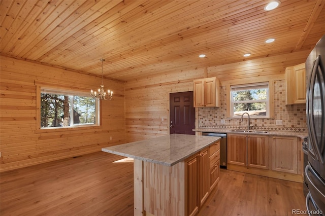 kitchen with a sink, light wood-type flooring, appliances with stainless steel finishes, and decorative backsplash