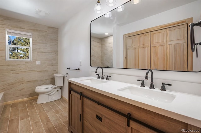 full bath featuring a sink, toilet, and double vanity