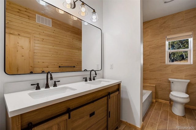 bathroom with a bathtub, visible vents, toilet, and a sink