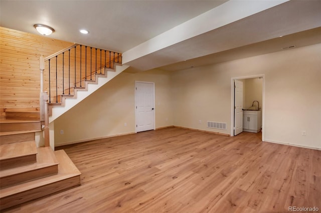 interior space with visible vents, baseboards, wood finished floors, and stairway