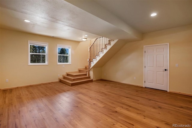 additional living space with recessed lighting, stairway, baseboards, and light wood-style flooring