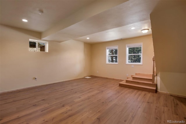 below grade area featuring recessed lighting, baseboards, wood finished floors, and stairs