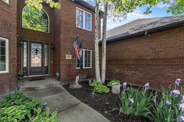 6940 Saddleback Ave, Firestone, CO 80504 - doorway to property featuring brick siding and roof with shingles