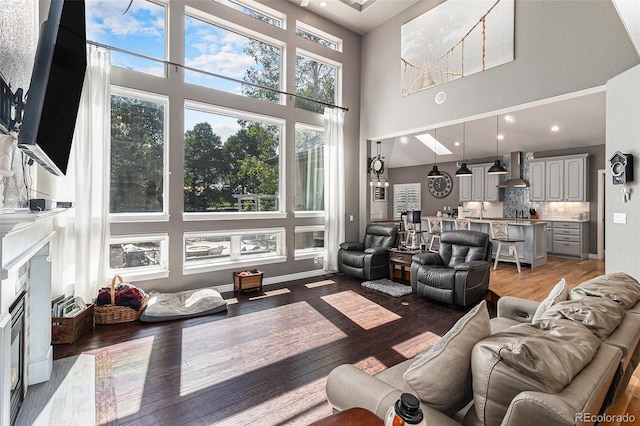 6940 Saddleback Ave, Firestone, CO 80504 - living area featuring a towering ceiling, healthy amount of natural light, light wood-type flooring, and a high end fireplace
