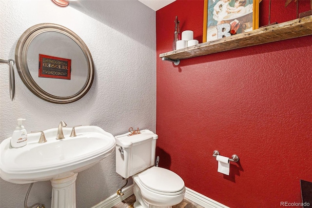 6940 Saddleback Ave, Firestone, CO 80504 - bathroom with toilet, a sink, wood finished floors, and baseboards