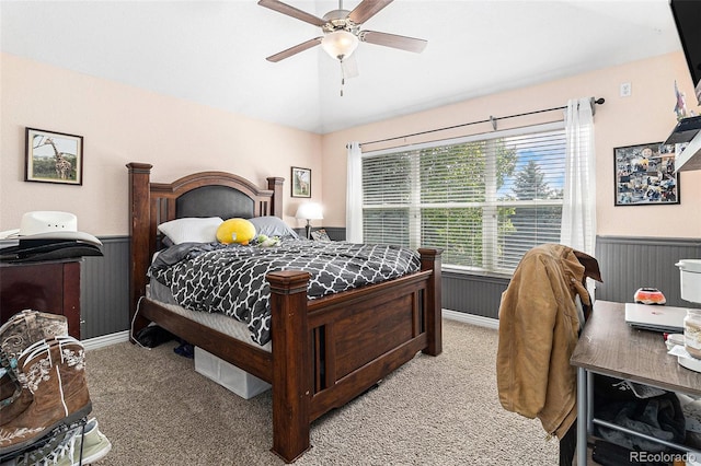 6940 Saddleback Ave, Firestone, CO 80504 - bedroom featuring light carpet, lofted ceiling, a wainscoted wall, and ceiling fan