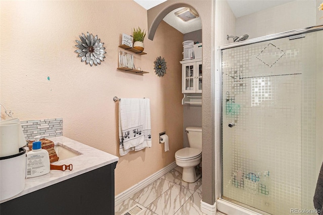 6940 Saddleback Ave, Firestone, CO 80504 - bathroom featuring toilet, a stall shower, vanity, marble look tiles, and baseboards