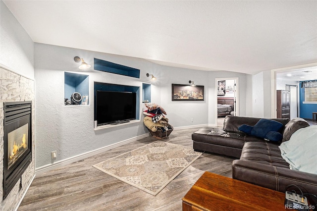 6940 Saddleback Ave, Firestone, CO 80504 - living room with a fireplace, wood finished floors, baseboards, and a textured wall