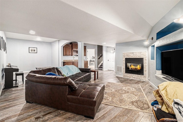 6940 Saddleback Ave, Firestone, CO 80504 - living area featuring baseboards, stairs, a lit fireplace, wood finished floors, and recessed lighting