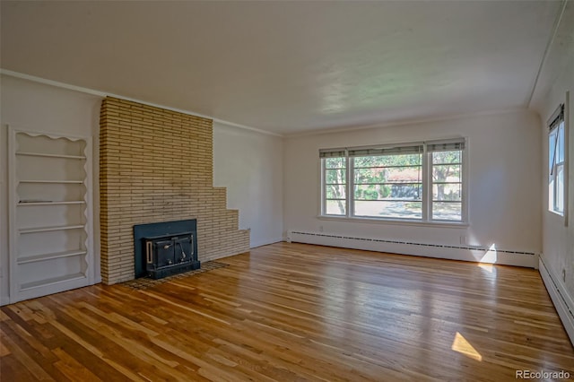 unfurnished living room with a baseboard radiator, crown molding, hardwood / wood-style floors, and a wood stove