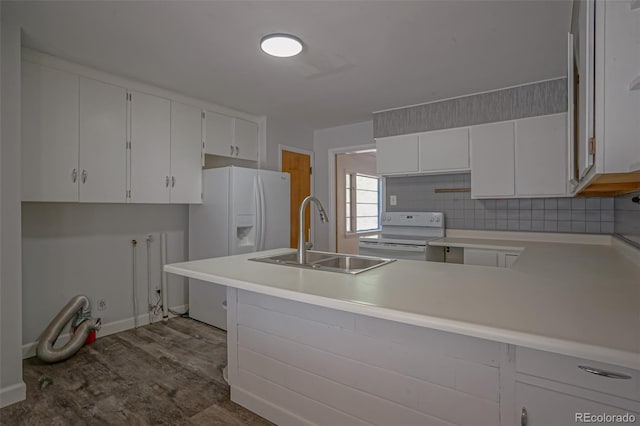 kitchen with tasteful backsplash, white appliances, sink, kitchen peninsula, and white cabinetry