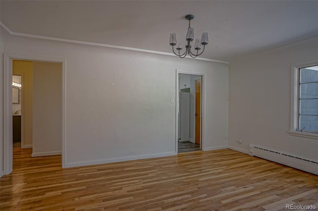 spare room with light wood-type flooring, a notable chandelier, and a baseboard radiator