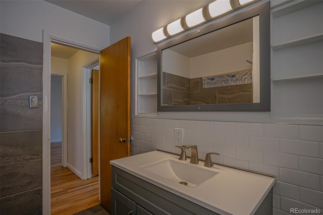 bathroom featuring hardwood / wood-style flooring, tile walls, vanity, and tasteful backsplash