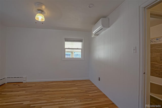 empty room featuring a wall mounted air conditioner and light wood-type flooring